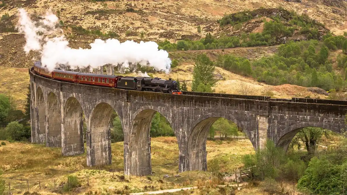 The Jacobite Steam Train crossing the 21-arch Glenfinnan Viaduct above the glen, the centerpiece of a Glenfinnan Viaduct tour from Edinburgh in the Scottish Highlands